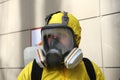 Paramedic wearing yellow protective costume and mask disinfecting coronavirus with the motorized backpack atomizer and sprayer