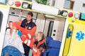 Paramedics checking IV drip patient in ambulance