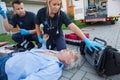 Paramedics checking pulse of unconscious man Royalty Free Stock Photo