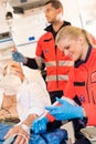 Paramedics injecting sick patient in ambulance aid