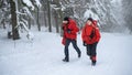 Paramedics from mountain rescue service running outdoors in winter in forest. Royalty Free Stock Photo