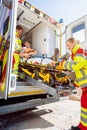 Paramedics putting injured man on stretcher in ambulance car