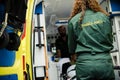 Paramedics rolling a young patient on an ambulance stretcher