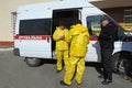 Paramedics sitting in the ambulance car putting yellow protective costumes and masks on preparing to disinfect coronavirus
