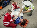 Paramedics stabilizing the patient. Policeman makes the breath t