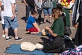Paramedics teaching resuscitation to people at an open day using a doll or dummy