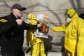 Paramedics wearing yellow protective costumes and masks disinfecting coronavirus with the motorized backpack atomizer and sprayer