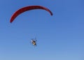 Paramotor flying on blue sky background