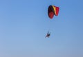 Paramotor flying on blue sky background