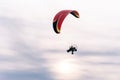 Paramotor flying in sky with clouds and sun Royalty Free Stock Photo