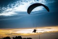 Paramotor flying on the sky at sunset.