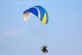 Paramotor pilot flying in a blue sky