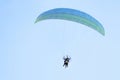 Paramotor pilot and his tourist client flying in the sky