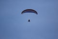 Paramotor pilot soaring on clear blue sky with red white blue gliding wing Royalty Free Stock Photo