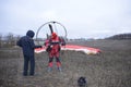 Paramotoring. Instructor helping the paramotorist to prepare equipment for flight