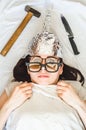 Paranoid girl wears foil hat and sleeps with weapon and different glasses because of mental disorder