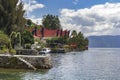 Guest houses in the form of a traditional Indonesian dwelling with a pier for boats on the Royalty Free Stock Photo