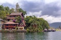 Guest houses in the form of a traditional Indonesian dwelling with a pier for boats on the Royalty Free Stock Photo