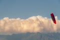 Paraplan flies amid mountains and blue skies with clouds