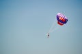 Parasailing. Man flies on parachute in clear blue sky. Side view. Copy space. Royalty Free Stock Photo