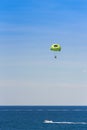 Parasailing over the sea in Salou, Tarragona, Catalunya, Spain. Copy space for text. on blue background. Vertical.