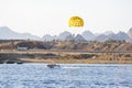 Parasailing parachute active sport sky sea boat. A speedboat pulls a yellow parachute with a tourist. Extreme entertainment for Royalty Free Stock Photo