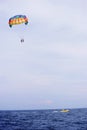 Parasailing in summer beach by speed boat, vertical composition