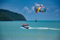 Parasailing on the waves of the azure Andaman sea under the blue sky near the shores of the sandy beautiful exotic and stunning Royalty Free Stock Photo