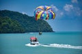 Parasailing on the waves of the azure Andaman sea under the blue sky near the shores of the sandy beautiful exotic and stunning Royalty Free Stock Photo