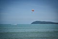 Parasailing on the waves of the azure Andaman sea under the blue sky near the shores of the sandy beautiful exotic and stunning Royalty Free Stock Photo