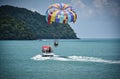 Parasailing on the waves of the azure Andaman sea under the blue sky near the shores of the sandy beautiful exotic and stunning Royalty Free Stock Photo