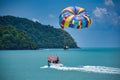 Parasailing on the waves of the azure Andaman sea under the blue sky near the shores of the sandy beautiful exotic and stunning