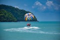 Parasailing on the waves of the azure Andaman sea under the blue sky near the shores of the sandy beautiful exotic and stunning Royalty Free Stock Photo