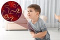 Parasites under microscope and boy suffering from helminthiasis Royalty Free Stock Photo