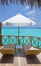 Parasol and chaise lounges on a terrace of water v