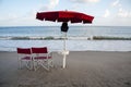 Parasol with foldout chairs against the horizon on the foreshore at dusk. Royalty Free Stock Photo