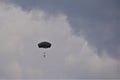 Paratrooper descends with open grey parachute