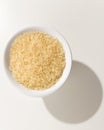 Parboiled Chinese Rice seed. Grains in a bowl. Shadow over white Royalty Free Stock Photo