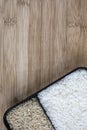 Parboiled white rice and integral rice on the wooden table Royalty Free Stock Photo