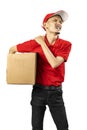 A parcel delivery man with a hat feels back pain while carrying a package Royalty Free Stock Photo