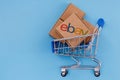 Parcel with eBay logo in the shopping cart on a blue background