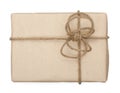 Parcel wrapped, gift box with brown kraft paper and tied with twine and bow. Isolated on white background, top view, close-up Royalty Free Stock Photo