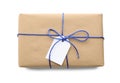 Parcel wrapped in kraft paper with tag on white background, top view Royalty Free Stock Photo