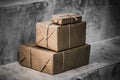 Parcels wrapped in brown paper in warehouse, packaged boxes for postal delivery service, concrete background with