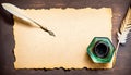 Parchment, quill and inkwell on a wooden table seen from above.