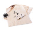 Parchment with stains of ink, feather pen and inkwell on white background Royalty Free Stock Photo