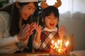 Parent and child blowing out a candle Royalty Free Stock Photo