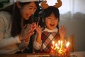 Parent and child blowing out a candle Royalty Free Stock Photo