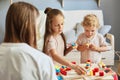 Parent-child bonding. Happy family time. Playful daycare activities. Parenting joy moments. Children playing together with mother Royalty Free Stock Photo