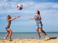 Parent and child play a ball at coast on a summer day Royalty Free Stock Photo